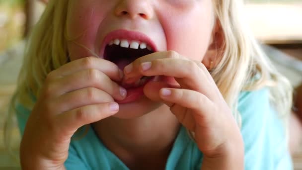 Il bambino mostra il suo primo dente sconcertante. Il dito allenta i denti dei bambini. — Video Stock