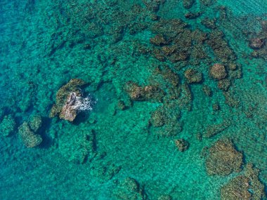 Kristal berrak turkuaz suyun havadan görünüşü. Surfac 'ın altında kayalar ve mercan oluşumları var.