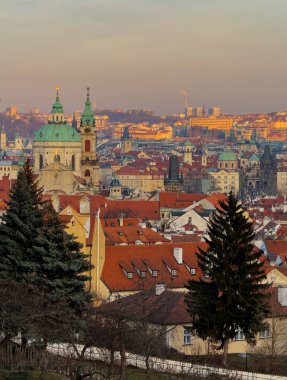 Kırmızı çatıları, yeşil kubbeli kilisesi ve tarihi silueti olan Avrupa şehrinin günbatımı manzarası