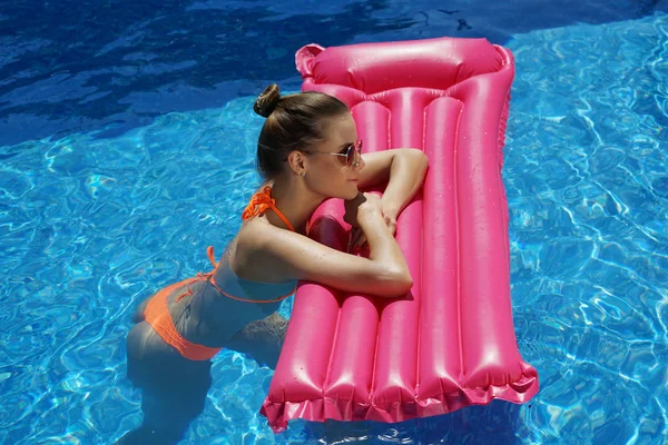 スイミング プールの空気マットレスを保持しているビキニの若い女性 — ストック写真
