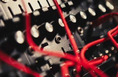 Müzik bestecisi için profesyonel elektronik sentezleyici paneli. Yüksek kalitede yeni müzik parçaları bestelemek için modern stüdyo sentetik paneli. Analog ses kayıt cihazına bağlı birçok ses kablosu