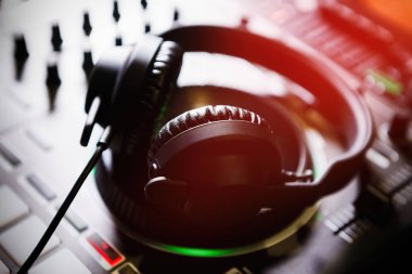 Stereo kafa müzik yüksek sesle oynamak için ayarla. Profesyonel kulüp dj kulaklık ve ses mikseri konser sahne alanı'nda. Parti gece kulübünde müzik parçaları karıştırma için disk jokey teknoloji.