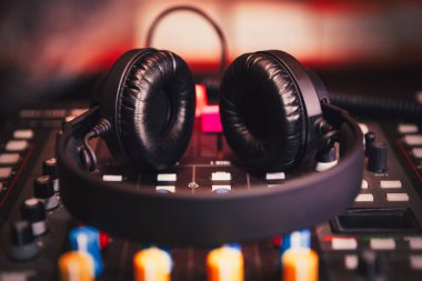 Stereo kafa müzik yüksek sesle oynamak için ayarla. Profesyonel kulüp dj kulaklık ve ses mikseri konser sahne alanı'nda. Parti gece kulübünde müzik parçaları karıştırma için disk jokey teknoloji.