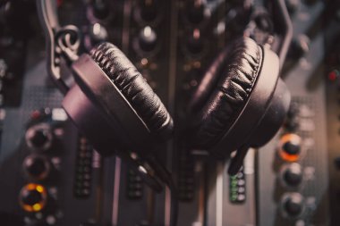Stereo kafa müzik yüksek sesle oynamak için ayarla. Profesyonel kulüp dj kulaklık ve ses mikseri konser sahne alanı'nda. Parti gece kulübünde müzik parçaları karıştırma için disk jokey teknoloji.