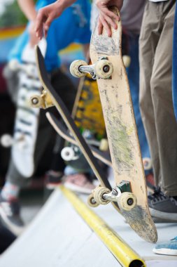 Patenci çocuklar skate yarışması Park binmek. Genç atlet eski kaykay el kontrplak rampa üstte ayakta tutar. Popüler gençlik spor