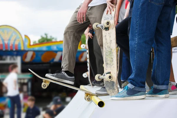 Grup Genç kaykaycı çocuklar üzerinde kaykaylar skatepark Yarışması'nda kullanıyormuş. Yaz doğa sporları arka plan. Popüler gençlik etkinliği. Gemide sporcular ayakları üzerinde odaklanmak