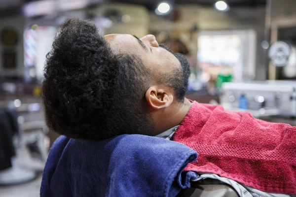 Joven Hombre Negro Sentado Sillón Peluquería Esperando Que Peluquería Corte —  Fotos de Stock