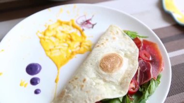 Jamon jambon dilim ile lezzetli tortilla kafede öğle yemeği için ıspanak ve domates ile servis. Lezzetli sağlıklı snack restoran brunch menüsünde için. Doğal malzemelerle iyi yemek zevk.