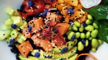 Lezzetli taze salata. Somon balığı, yeşil fasulye, avokado, siyah pirinç beyaz kase yemek kafede masada servis dilimlenmiş. Restoran öğle yemeği için doğal gıda görüntüleri. Zengin tadı ile sağlıklı beslenme.