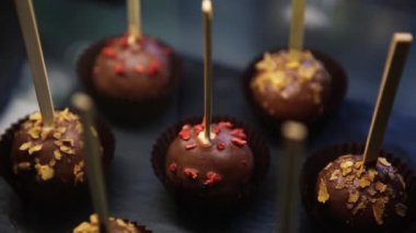 Lezzetli çikolatalı bonbon şekerler siyah arduvaz kara tahta Cafe servis sopa üzerinde. Lezzetli tatlı tatlı yiyecek ekmek içinde. Restoran zengin kakao şeker tadında keyfini çıkarın.