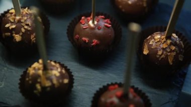 Lezzetli çikolatalı bonbon şekerler siyah arduvaz kara tahta Cafe servis sopa üzerinde. Lezzetli tatlı tatlı yiyecek ekmek içinde. Restoran zengin kakao şeker tadında keyfini çıkarın.