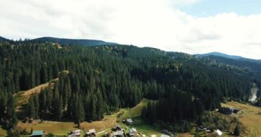Küçük orman kasaba tepelerde yeşil orman ve yüksek kayalık Karpat Dağları ile çevrili Ukrayna güzel dron görüntüleri. Güney Avrupa'nın aktif Turizm için seyahat hedef.