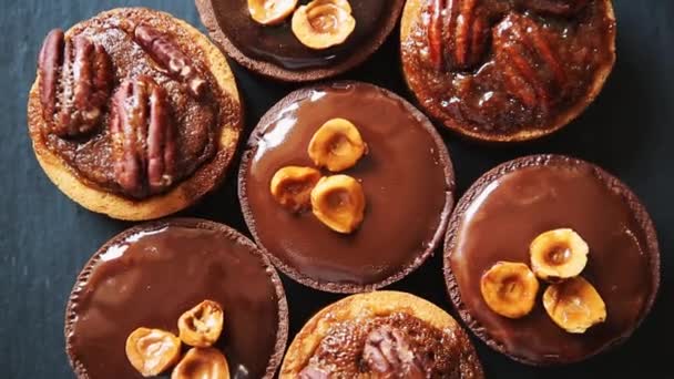 Lahodný čokoládový dort s ořechy a kakao moučkový na posypání podává v kavárně na oběd. Chutné koláčky na večeři. Záběry z sladký dezert jídlo v zblízka.