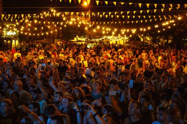 Kiev-11 Temmuz, 2018: Büyük bir grup genç insan yaz müzik festivali Bazar parti dışında. En sevdiğim müzisyen perfroming sahnede konser fanlar dalga eller. Olay Seyirci sahnede üzerinden görüntülemek