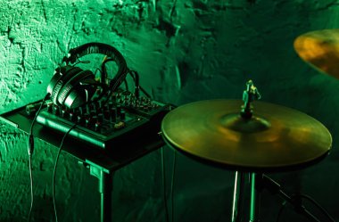 Rock konseri canlı müzik çalmak için ses ekipmanları profesyonel davulcu. Parlak yeşil sahne ışıkları gece kulübünde kiti ziller ve stereo kulaklık monitörler davul