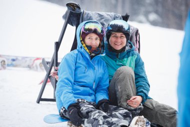 Bukovel, Ukrayna-19 Mart, 2018: Gülümseyen iki mutlu binici kız portresi. Kadın sporcular Koruyucu baretler ve sıcak giysiler giyiyor. Kış eylem Festivali kar Park spor