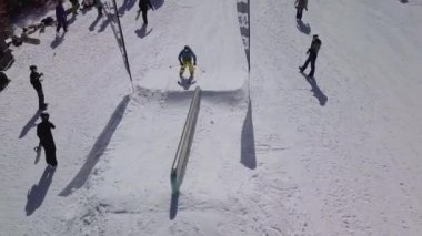 YAREMCHE, UKRAINE - 24 MARCH, 2018: Snowboarders & free ski riders take part in jib contest.Athletes grind on rail in Bukovel Snow Park.Extreme winter sport competition for young and active sportsmen.