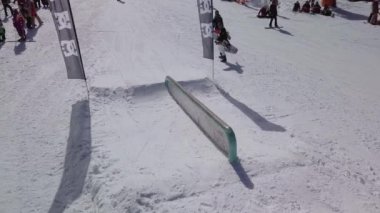 YAREMCHE, UKRAINE - 24 MARCH, 2018: Snowboarders & free ski riders take part in jib contest.Athletes grind on rail in Bukovel Snow Park.Extreme winter sport competition for young and active sportsmen.