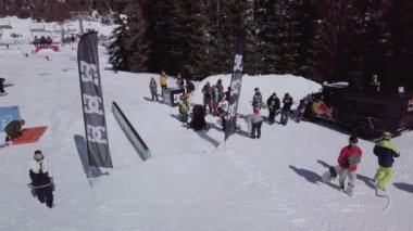 YAREMCHE, UKRAINE - 24 MARCH, 2018: Snowboarders & free ski riders take part in jib contest.Athletes grind on rail in Bukovel Snow Park.Extreme winter sport competition for young and active sportsmen.