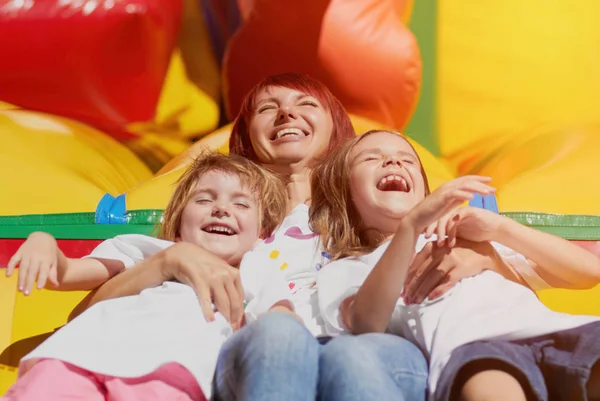 Young Loving Mother Her Cute Daughters Sitting Bouncing Castle Outdoors — Stock Photo, Image
