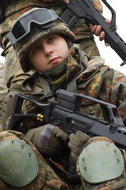 Askeri yardım. Ordu takım çalışması. Savaş üniforması içinde Ukraynalı ordunun kamuflajında silahlı askerler. Soldier takım üyesi tırmanmaya kaya açık yardımcı olur. Savaş Doğu Ukrayna. Heavy mühimmat, otomatik tüfek