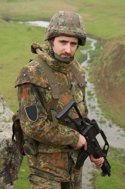 Genç bize otomatik tüfek ile SWAT asker çocuk. Kamuflaj kurşun geçirmez kask ateş hedef silah ile asker