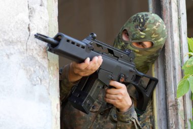 hedef otomatik g36 tüfeği ile nişan kamuflaj maskeli adam  