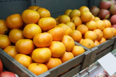 Gıda pazarında satışa turuncu meyve kutusuna yakın. Bakkal meyve departmanında süpermarket satan taze olgun meyveler. Doğal sağlıklı gıda malzemeleri. Satın almak ve vitaminler yemek  