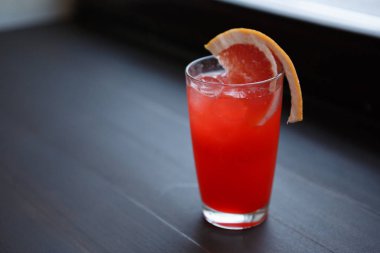 Cam kırmızı ekşi alkollü içecek. Lezzetli uzun doğal taze meyve suyu ile bir içki tadını çıkarın. Barda serinletici uzun içecekler