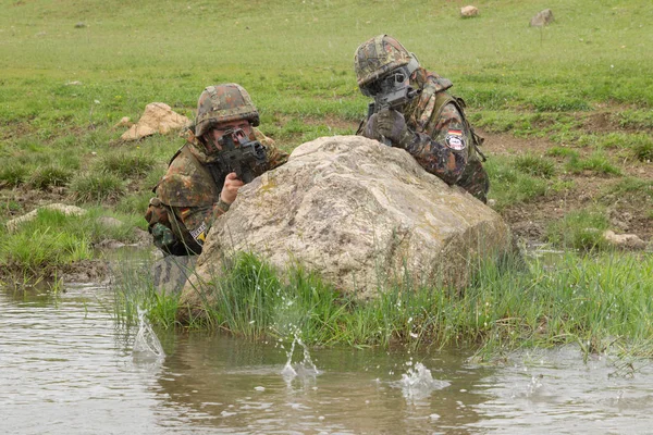 Military assistance.Army teamwork.Armed soldiers in camouflage of Ukrainian army in combat uniform.War in Eastern Ukraine.Heavy ammunition,automatic rifle