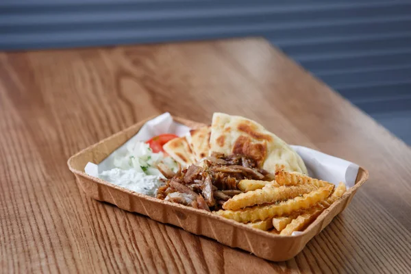 Traditional Greek fast food restaurant menu.Souvlaki & gyros meat sandwich dish from Greece served in paper plate.Tasty roasted fastfood on table in cafe.Enjoy meal