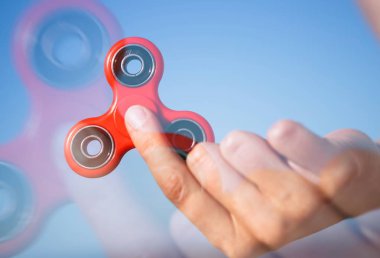 Serin yeni topluca spinner oyuncak el içinde. Kız çok popüler gadget parmaklarını içinde tutun. Bu oyun ile serin yeni iplik hileci öğrenin. Rulmanlar orta, kırmızı renk Nesnedeki döndürme. Dikey vurdu