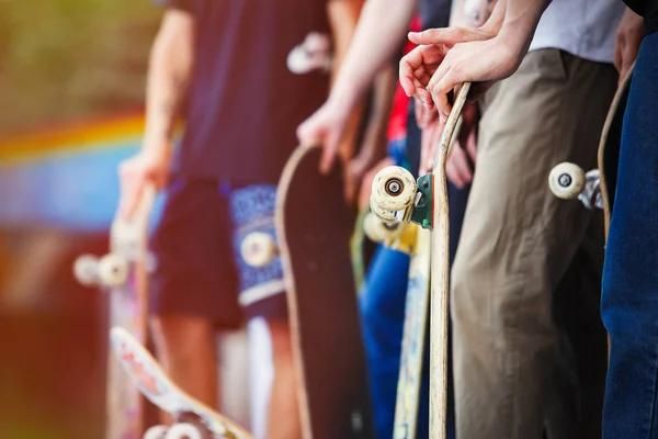 在阳光明媚的夏日 溜冰男孩们在户外的户外滑雪场参加比赛 滑板手的家伙手里拿着旧甲板 准备骑行表演技巧 流行的青少年运动和生活方式 — 图库照片