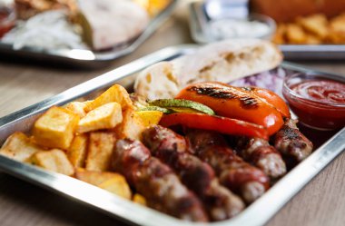 Kafede lezzetli egzotik fastfood menü. Geleneksel Sırp yemek menüsü ile kavrulmuş et, peynir füme ve kızarmış patates. Gıda kompozisyon arka plan. Atış yiyecekleri kapatın 