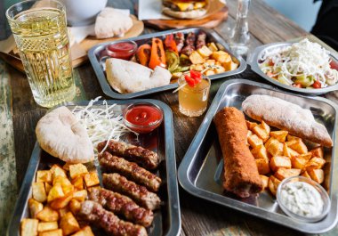 Fast food restoran menüde lezzetli geleneksel Sırp yemek keyfini çıkarın. Egzotik menü öğle yemeği için. Izgara Dana eti, kızarmış peynir ve kızarmış patates kafede görev yaptı. Gıda kompozisyon arka plan   