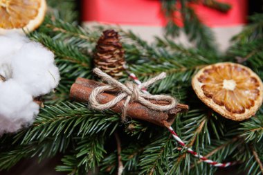 Dekoratif Noel ve Yılbaşı tatil çelenk. Portakal meyve, mumlar, tarçın çubukları ile köknar ağacı dalı. Ev yapımı süslemeleri ile evinizi süsleyin. Kare kumaş arka damla  