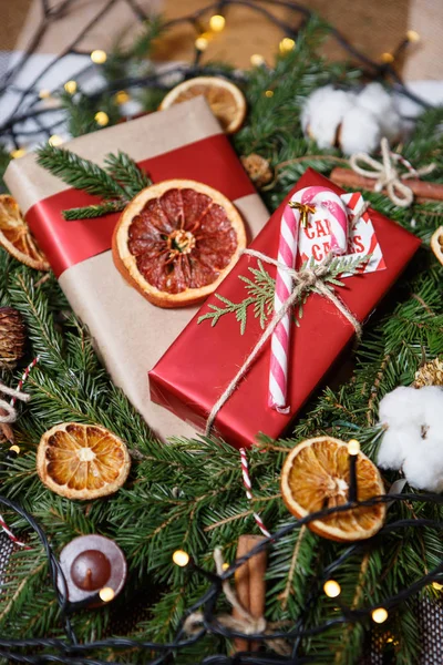 美丽的装饰圣诞节和新年礼物在礼品盒躺在圣诞树的冷杉树枝 节日礼品装饰 红色闪亮的包裹与棍子和分支 — 图库照片