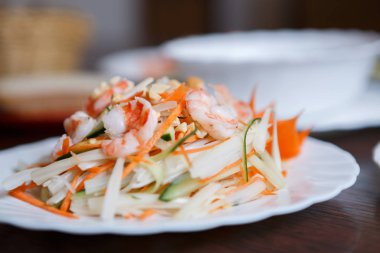 Egzotik Vietnam gıda restoran menü kapatın. Geleneksel Asya yemeği beyaz tabakta. Taze haşlanmış karides, fıstık ve dilimlenmiş lahana