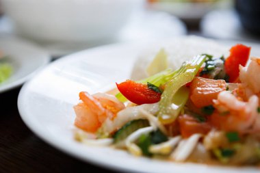 Egzotik Vietnam gıda restoran menü kapatın. Geleneksel Asya yemeği beyaz tabakta. Taze haşlanmış karides, fıstık ve dilimlenmiş lahana 