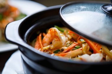 Kase karides sos ve sebze ile kapalı. Egzotik Vietnam yiyecek yemek listesi içinde restoran. Çin restoranı Asya Deniz ürünleri yemek. Yakın çekim, pan kapak sıcak su damla ile odaklanmak