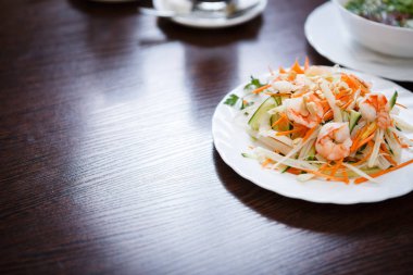 Egzotik Vietnam gıda restoran menü kapatın. Geleneksel Asya yemeği beyaz tabakta. Taze haşlanmış karides, fıstık ve dilimlenmiş lahana