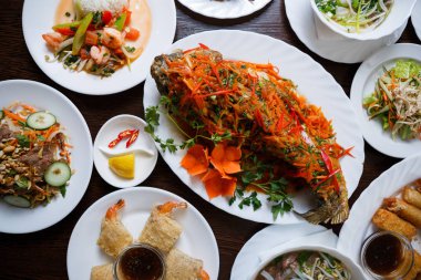 Geleneksel Vietnam salata ve deniz ürünleri ile baharatlı kızarmış karp balık closeup çekim. Makro büyük Asya restoran yemek. Karides rulo, yılan balığı salatası ve pho bo çorba servis Çin kafede masada