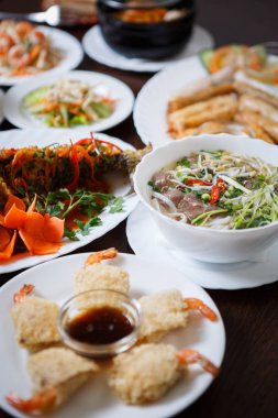 Geleneksel Vietnam salata ve deniz ürünleri ile baharatlı kızarmış karp balık closeup çekim. Makro büyük Asya restoran yemek. Karides rulo, yılan balığı salatası ve pho bo çorba servis Çin kafede masada