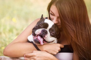 genç esmer kız parkta onun sağlıklı genç bulldog ile oynarken 