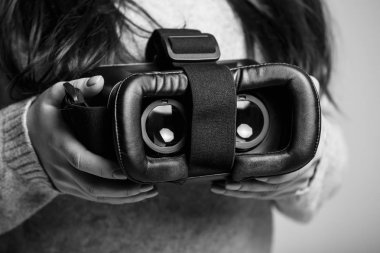 Kız modern sanal gerçeklik gözlük mobil oyun uygulama için basılı tutun. Mobil uygulamalar kullanmak, video oyunları her yerde oynamak. Yakın çekim, kadın elinde vr kulaklıktaki odaklan. Trendy yeni augmented reality gaming aygıt