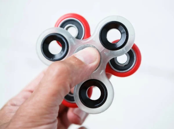 Boy play with popular finger spinner device.Modern fidget spinning toy on bearings.Spin it in hands & learn cool new tricks.Have fun with this new rotating gadget.