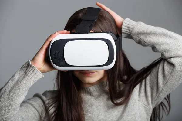 Young girl playing mobile game app on virtual reality headset device.Modern VR box for mobile gaming.Portable vr glasses technology for gamers.Augmented reality gadget to play moblie games