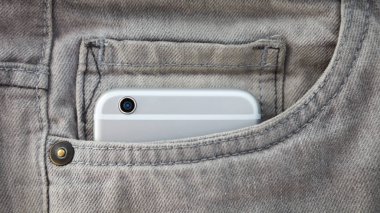  Kot cebinde büyük modern akıllı telefon. Her zaman bağlı kalmak ve harika fotoğraflar çekmek için yeni akıllı telefon satın alın. Odak cep telefonu kamera lensi. Gri pantolon cebinde modern cihaz. Yeni gri akıllı telefon.