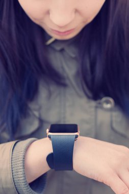 Bilek üzerinde akıllı saatini dokunmadan parka genç kız. Bu yeni becerikli alet her zaman internet ve sosyal medya ağları ile istediğiniz yerden bağlı kalmak sağlar. 