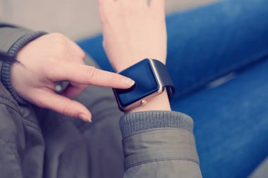 Bilek üzerinde akıllı saatini dokunmadan parka genç kız. Bu yeni becerikli alet her zaman internet ve sosyal medya ağları ile istediğiniz yerden bağlı kalmak sağlar. 